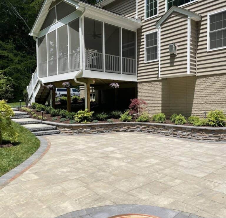 Elegant backyard outdoor living space with landscaped gardens, stone retaining wall, and spacious patio for relaxing and entertaining. Perfect for outdoor gatherings and enjoying nature.