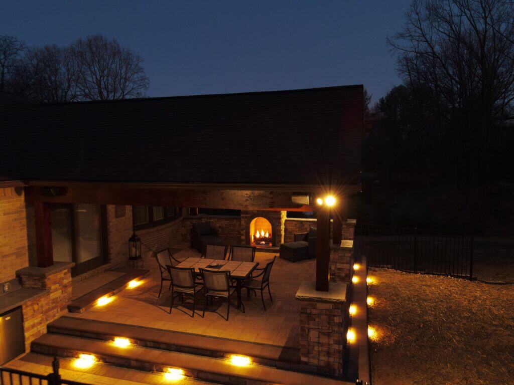 Cozy outdoor living space with fire pit, dining area, and landscape lighting, perfect for relaxing evenings and outdoor entertaining. Designed for comfort and style in your backyard oasis.