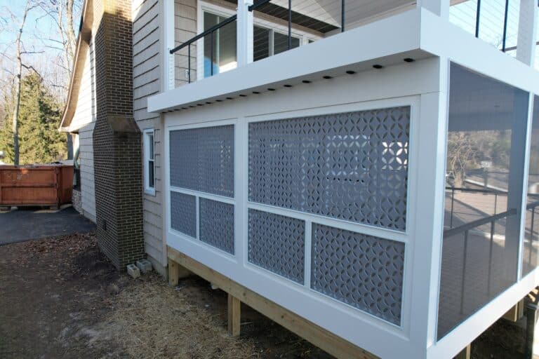Stylish screened porch addition for outdoor living space, providing privacy and bug protection with decorative lattice panels and modern design elements.