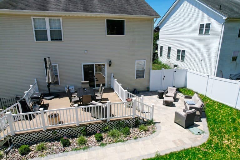 Spacious backyard outdoor living space with wooden deck, comfortable seating area, and landscaped garden for relaxing and entertaining. Perfect for outdoor gatherings and enjoying nature.