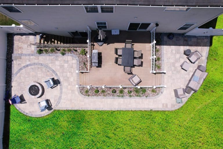 Spacious backyard outdoor living space featuring a multi-level deck, cozy seating area, fire pit, and landscaped garden for relaxing and entertaining.