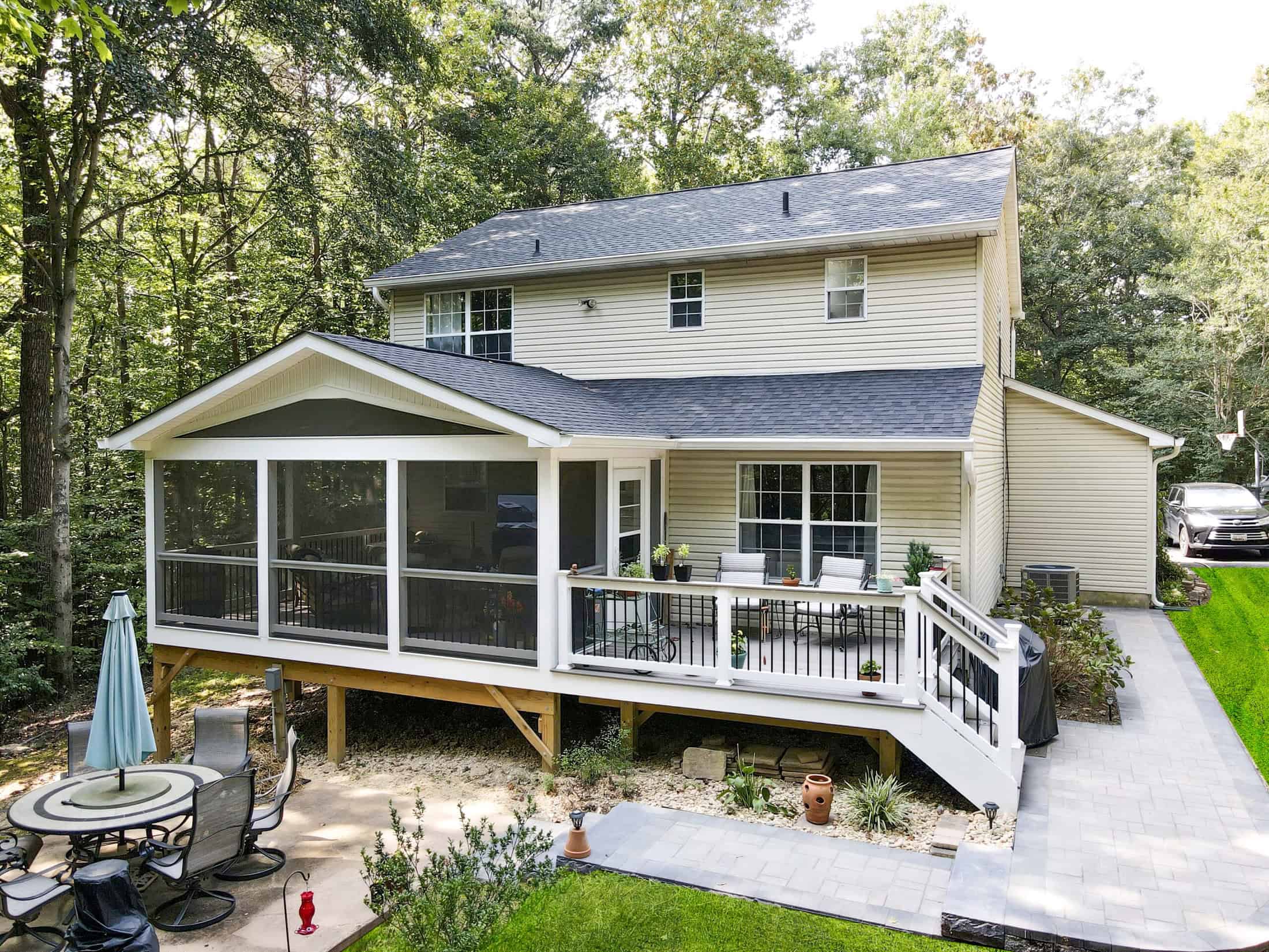 Beautiful backyard with a spacious screened-in porch, outdoor dining area, and lush greenery for relaxing outdoor living spaces.