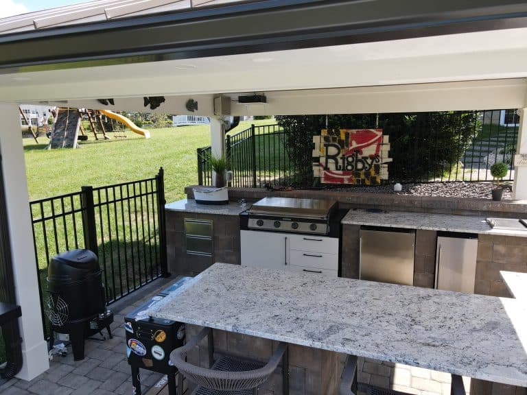 Custom outdoor kitchen with granite countertops, gas grill, and modern cabinetry for outdoor living spaces. Perfect for entertaining in your backyard with a stylish, functional setup.