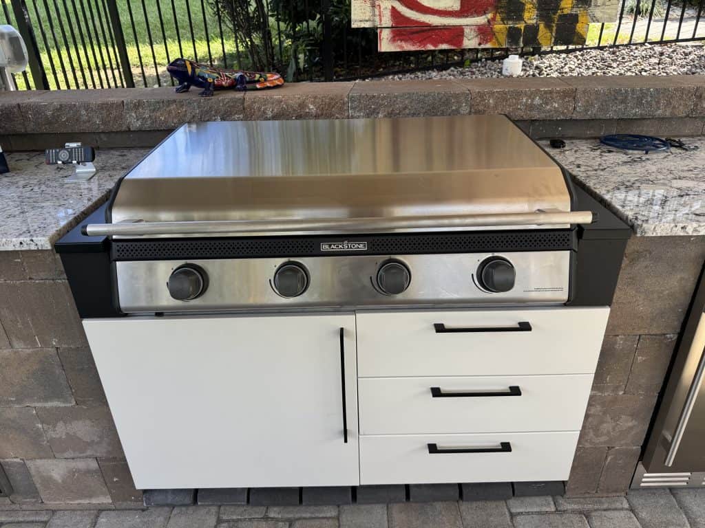 Blackstone stainless steel outdoor grill on a modern outdoor kitchen countertop with drawers, perfect for outdoor living spaces and cooking.