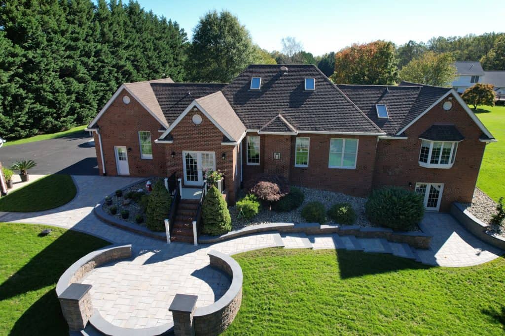 Beautiful brick house with landscaped yard, patio, and outdoor seating area, perfect for outdoor living and entertaining.
