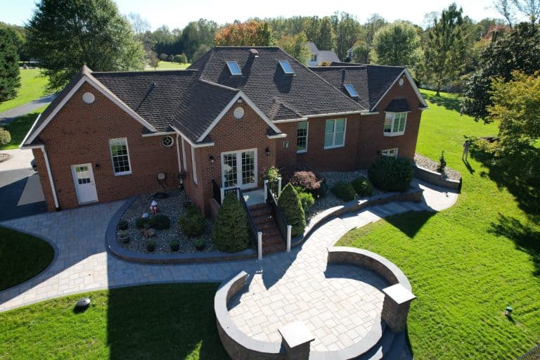 A spacious backyard with a modern patio, lush green lawn, and landscaped garden, perfect for outdoor entertaining and relaxation.